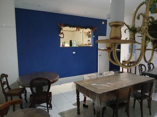 a dining room with a blue wall and a table and chairs at Mangue Oranje Hostel - no bairro do Recife Antigo - Old Town in Recife