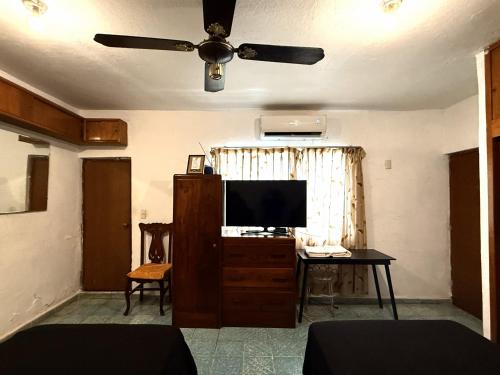 a living room with a ceiling fan and a television at Acogedora habitación en excelente ubicación in Mazatlán