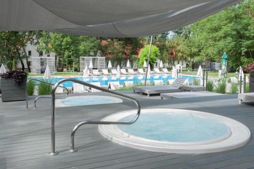 a hot tub in a deck next to a swimming pool at Varga Tanya Hotel in Kerekegyháza