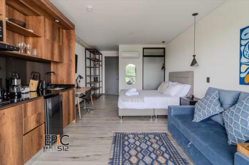 ein Wohnzimmer mit einer blauen Couch und einem Bett in der Unterkunft Epic Suite 512 Deluxe Airport in Cuba