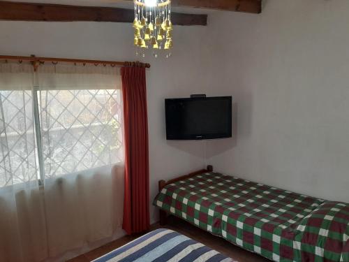 een kamer met een tv, een bed en een raam bij Las Cruces, Sector Playa Chica in San Antonio