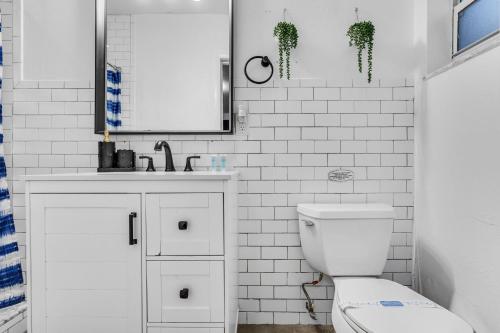 une salle de bains blanche avec toilettes et lavabo dans l'établissement Miami Dream Home With 4 Bedrooms Game Room And Backyard Oasis, à North Miami Beach