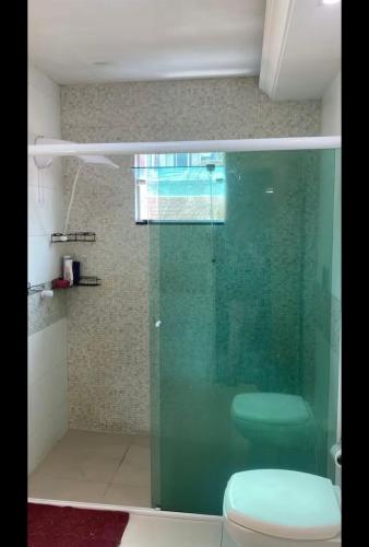 a bathroom with a glass shower with a toilet at My House in Itajaí