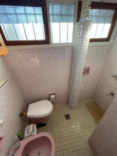 a bathroom with a pink toilet and a sink at PH con cochera cubierta cerca de la playa in Villa Gesell