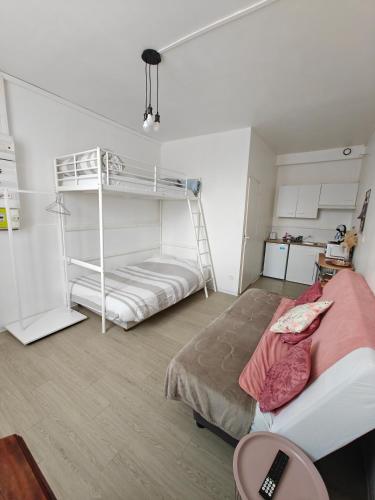 a bedroom with two bunk beds and a desk at Le studio Mauperthuis in Forges