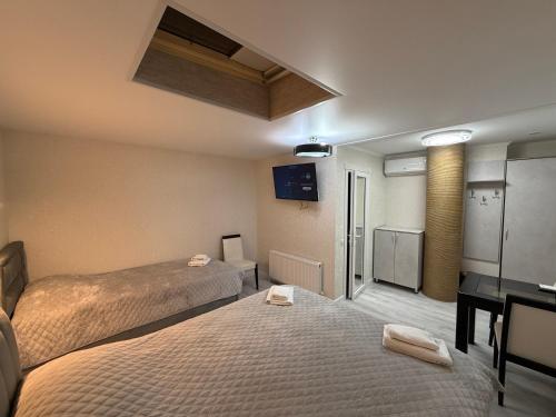 a hotel room with two beds and a desk at Hotel Kalyan & Spa in Chişinău