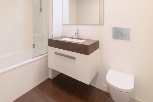 a white bathroom with a sink and a toilet at Madeira Palace Ocean View in Funchal