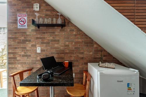 a kitchen with a table with a laptop on a counter at Estúdio com ar condicionado próximo ao centro e UDESC CEFID in Florianópolis