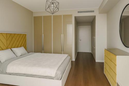 a bedroom with a white bed and a mirror at Madeira Palace Ocean View in Funchal