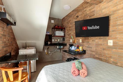 a room with a bed and a brick wall at Estúdio com ar condicionado próximo ao centro e UDESC CEFID in Florianópolis