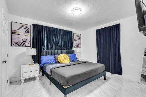 une chambre avec un lit avec des oreillers bleus et jaunes dans l'établissement Miami Dream Home With 4 Bedrooms Game Room And Backyard Oasis, à North Miami Beach