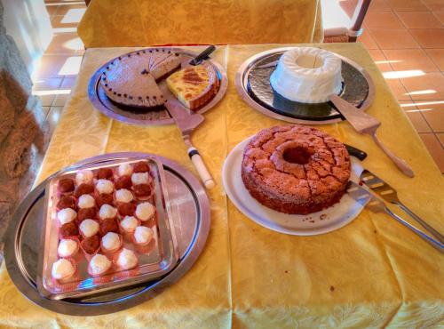 a table topped with different types of cakes and pastries at Hotel Residence Villa Rioddi in Volterra