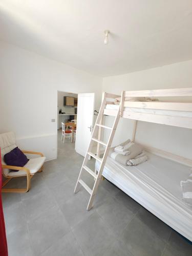 a room with two bunk beds and a chair at L'Orangerie du Domaine F3 in Forges