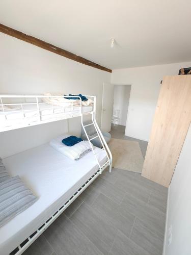 a bedroom with two bunk beds in a room at Le Grand Mauperthuis F4 in Forges