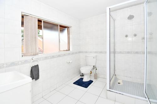 een witte badkamer met toilet en douche bij Sandton Elite Stay in Sandton