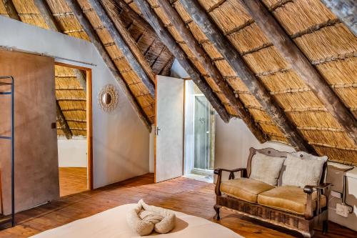 a room with a couch and a chair in a room at The ChaBo Lodge in Marloth Park