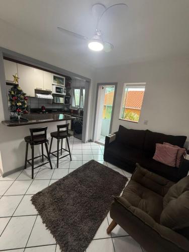 een woonkamer met een bank en een keuken bij Apartamento inteiro 45m, centro, com garagem in Torres