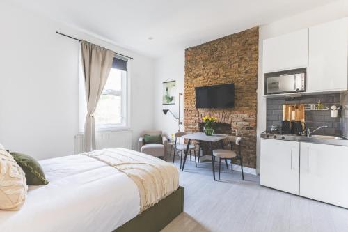 a bedroom with a bed and a kitchen with a sink at Amazing serviced accommodations for Corporate Contractors and Leisure clients Located at a walking distance from three majors Underground and Overground stations in London