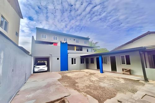 a white building with a car parked in a driveway at Thebluee Matinhos beach in Matinhos