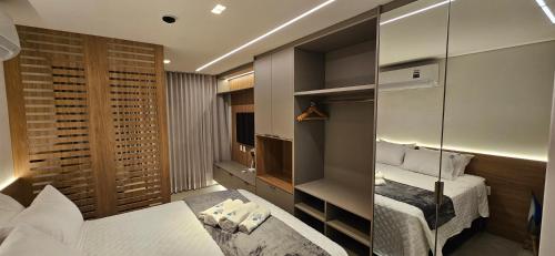 een hotelkamer met een bed en een spiegel bij Beach Class Verano Muro Alto in Porto De Galinhas