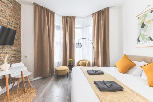 a bedroom with a white bed and a brick wall at Amazing serviced accommodations for Corporate Contractors and Leisure clients Located at a walking distance from three majors Underground and Overground stations in London