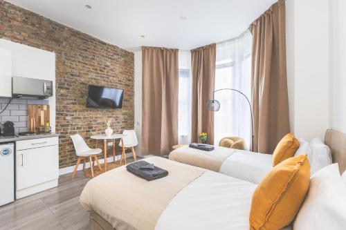 a hotel room with two beds and a kitchen at Amazing serviced accommodations for Corporate Contractors and Leisure clients Located at a walking distance from three majors Underground and Overground stations in London