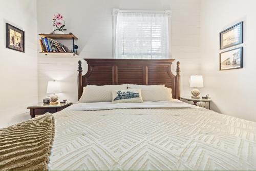 a bedroom with a large bed with a wooden headboard at The Island Suite at KW Vacation in Key West
