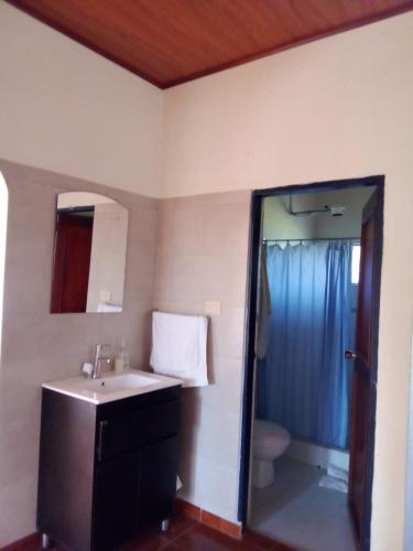 a bathroom with a sink and a toilet and a mirror at Finca Turistica Rancho Grande in Santana