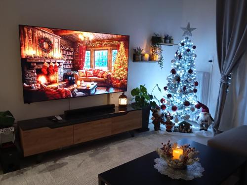 a living room with a christmas tree and a tv at Ηome & Garden with parking close to Olympic Stadium in Athens
