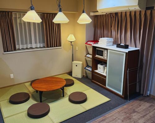 a room with a table and stools in a room at Beagle Tokyo Hostel＆Apartments in Tokyo