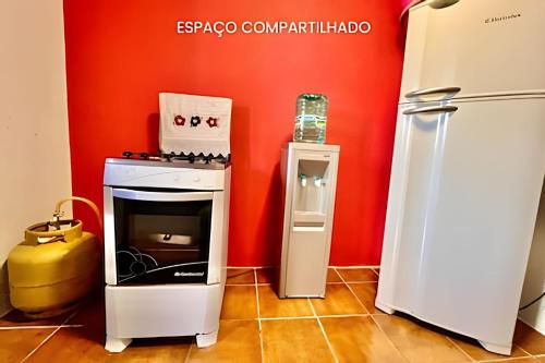 een keuken met een fornuis en een koelkast bij Quarto Praia Economico in Matinhos