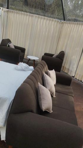 a couch with pillows on it in a room at Cusco Sana Lodge in Cusco