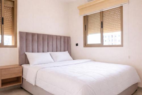 een slaapkamer met een wit bed en 2 ramen bij 2 bedrooms abouab gueliz in Marrakesh