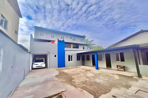 un edificio bianco con un'auto parcheggiata in un vialetto di The Red, Vem que tem Sol a Matinhos