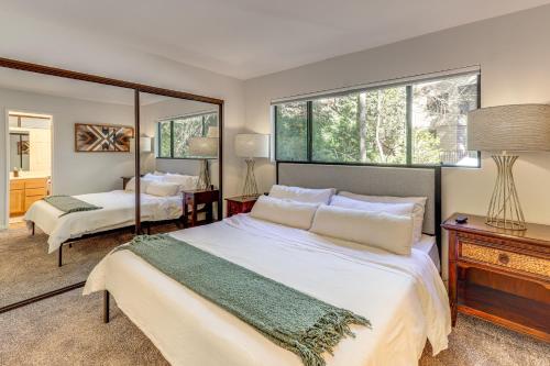 een slaapkamer met twee bedden en een spiegel bij 2 Decks! Pet-Friendly Lake Arrowhead Cabin in Skyforest
