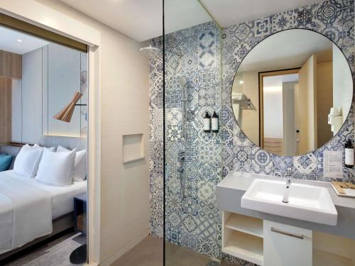 a bathroom with a sink and a mirror at Mercure Samarinda in Samarinda