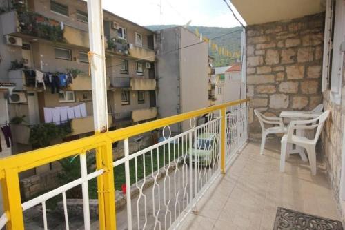 a balcony with a yellow railing and a table and chairs at Apartments Mat in Vis