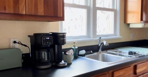 a kitchen counter with a coffee maker next to a sink at 1 Min to Hospitals Spacious 4 Bed Stay in Billings