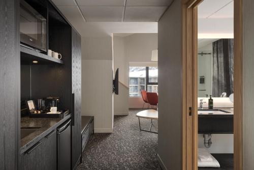 een keuken met een wastafel en een tafel in een kamer bij Peaks Hotel and Suites in Banff