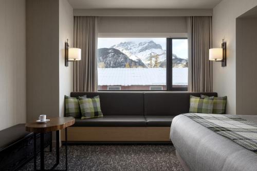 een hotelkamer met een bank en een raam bij Peaks Hotel and Suites in Banff