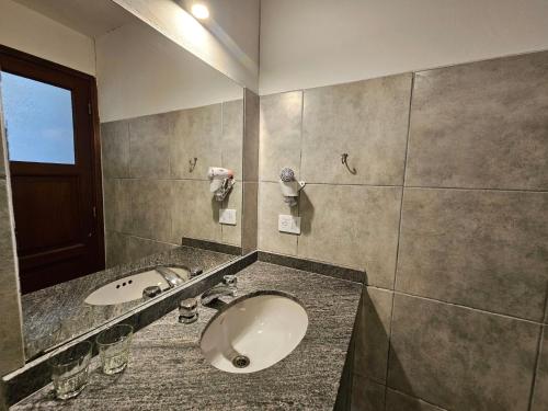 une salle de bains avec un lavabo et un miroir dans l'établissement Hotel Selva Montana, à San Lorenzo