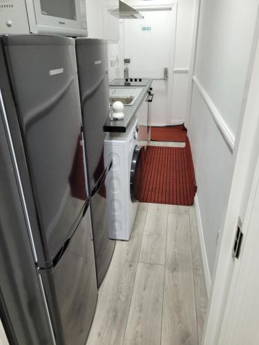 a small kitchen with a stainless steel refrigerator at 525 Romford Rd, Fabulous Room in London