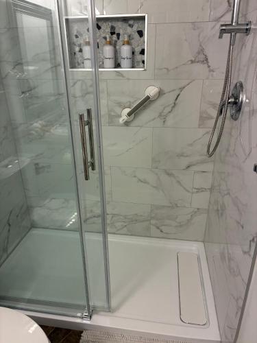a shower with a glass door in a bathroom at Memory Lane Guest Suite in Sooke