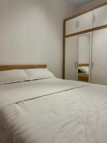 a bedroom with a white bed and a mirror at Apartment DUNJA Laktasi in Laktaši