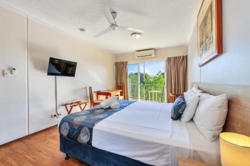 a bedroom with a large bed and a balcony at Cullen Bay Resorts in Darwin