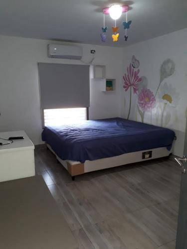 a bedroom with a bed with a blue comforter at CASA CON PILETA EN EL CENTRO de CORRIENTES in Corrientes