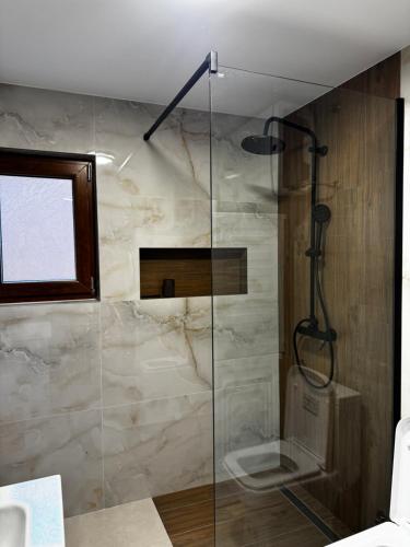 ein Badezimmer mit Glasdusche und WC in der Unterkunft Monte Rustic Chalets in Mojkovac