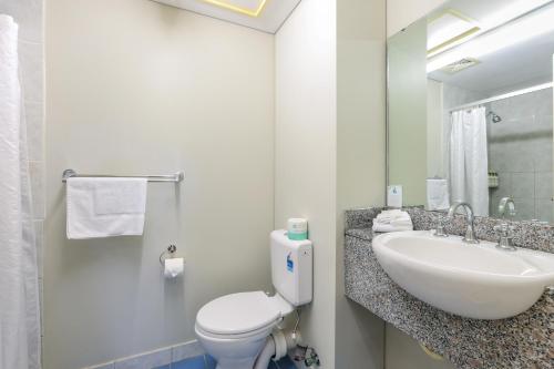 een witte badkamer met een wastafel en een toilet bij Cullen Bay Resorts in Darwin