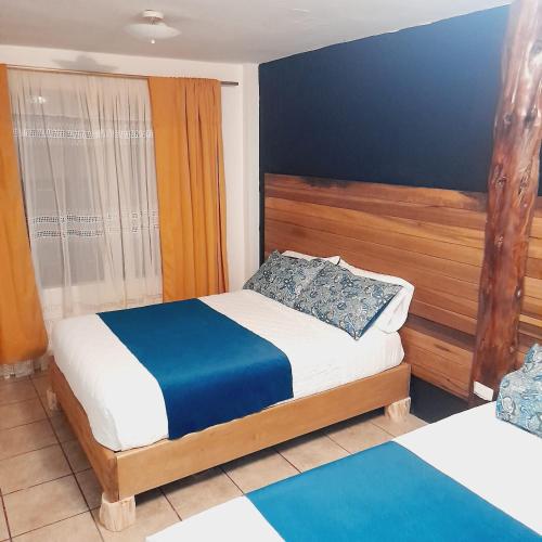 a bedroom with a bed with a blue and white at Casa Descanso y Madera in Baños