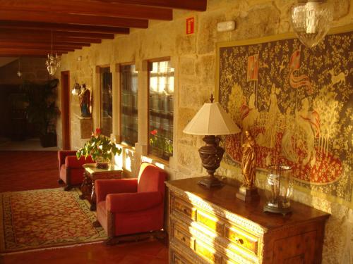 a living room with a couch and chairs and a lamp at Pazo a Capitana in Cambados